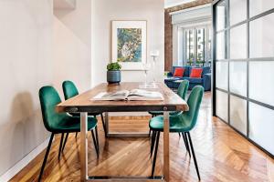 伦敦Premium Belgravia Harrods Apartment的一间带木桌和绿色椅子的用餐室