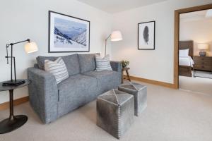 阿尔塔The Snowpine Lodge的一间带灰色沙发的客厅和一间卧室