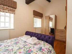 兰卡斯特Balloo的一间卧室配有一张紫色床和毛巾