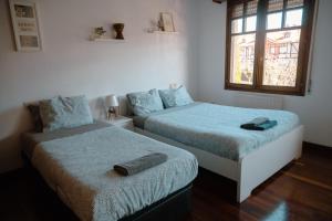 桑迪卡Chalet Bilbao-Aeropuerto的一间卧室设有两张床和窗户。
