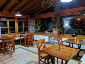 博比亚达里巴雷克萨库乡村酒店的一间带木桌椅的餐厅和一间酒吧