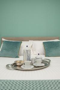 那不勒斯Maison Morghen的床上的带茶具和蜡烛的托盘