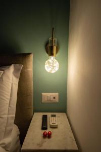 那不勒斯Maison Morghen的一间设有床、灯和遥控器的房间