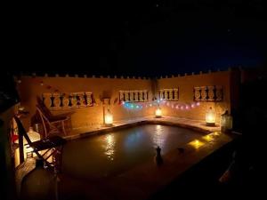 锡瓦غزاله كامب的夜间游泳池,配有蜡烛和灯光