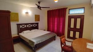 帕讷杜勒Jayaa Villas Bolgoda的一间卧室配有一张床和吊扇