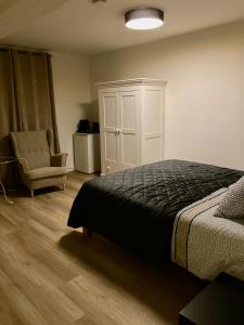 马斯特里赫特Hoeve de Hoge Swaen的一间卧室配有一张床、一个橱柜和一把椅子