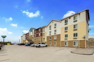 埃尔帕索WoodSpring Suites El Paso的停车场内有停车位的公寓大楼
