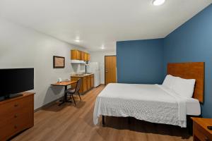 埃尔帕索WoodSpring Suites El Paso的酒店客房,配有床和电视