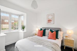 曼彻斯特1 Sarah House by Truestays - 2 Bedroom Apartment - FREE Wifi & Parking的白色卧室配有带橙色和绿色枕头的床