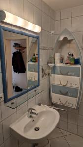 岑平"Ab zum Strand"的一间带水槽和镜子的浴室