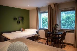 Loon op ZandHotel B&B Buiten Loon的一间卧室配有两张床和一张桌子及椅子