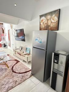 KwaleSea la vie II的厨房配有不锈钢冰箱和电视。
