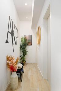 布达佩斯AK7 Boutique Suites的一条带白色墙壁和花瓶的走廊
