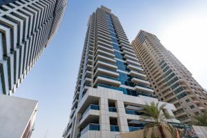 迪拜Marina Yacht Club Views - 3BR Modern Furnished的两座高大的建筑,前面有棕榈树