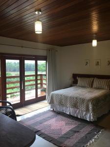 多明戈斯马丁斯Villa Uliana - Bangalôs VILLA的一间卧室设有一张床和一个滑动玻璃门
