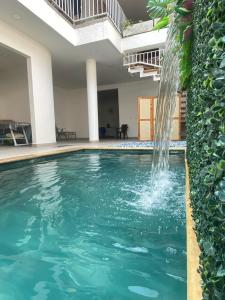 帕尔米拉Hotel Boutique Iyarí的一座房子里一个带瀑布的游泳池