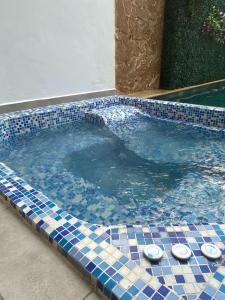 帕尔米拉Hotel Boutique Iyarí的拥有蓝色和白色瓷砖的游泳池