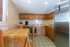 布雷拉Guest house Lenka的厨房配有桌子和不锈钢冰箱。