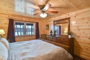 博因福尔斯3-Storey Home with Gorgeous Deck on Bows Lake ➠ 9776的一间卧室配有一张床和吊扇