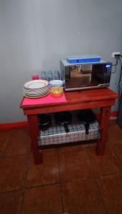 马那瓜Villalobos Hotel Managua的红色桌子上放有盘子和微波炉