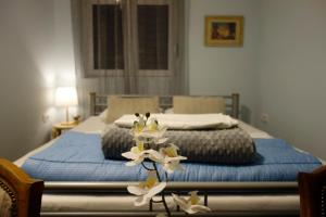 贝尔格莱德Villa Loop Beograd的一间卧室配有两张床,桌子上摆放着白色的鲜花