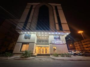 麦加جوهرة الديارJawaharat Al Diar的一座大型建筑,在晚上有大塔