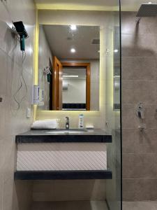 拉合尔Homey Stays - 2 Bedroom Apartment - Gulberg的一间带水槽、镜子和淋浴的浴室