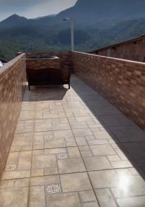 伊塔蒂亚亚Casa baiana的砖墙上的阳台配有长凳