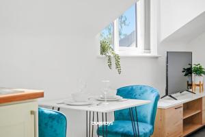 曼彻斯特6 Sarah House by Truestays - 2 Bedroom Apartment - FREE Wifi & Parking的一间带桌子和蓝色椅子的用餐室
