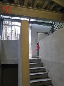 诺伊斯·勒·格兰德Appartement bien situé的一座建筑的楼梯,上面有红箭