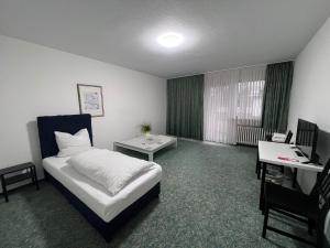 勒沃库森Haven - Hotel Am Stadion的酒店客房配有一张床、一张书桌和一台电脑