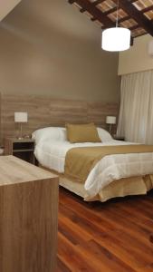 拉库布蕾Hotel Intersur La Cumbre的一间卧室设有两张床,铺有木地板