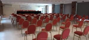 拉库布蕾Hotel Intersur La Cumbre的一间设有红色椅子的房间和一个背景舞台