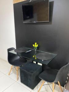 若昂佩索阿Flat Manaíra Palace Beira Mar的一张带两把椅子的黑桌和墙上的电视