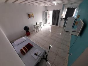 伊塔博拉伊Hospedagem Suites Itaboraí的客房设有床、桌子和冰箱。