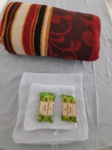 伊塔博拉伊Hospedagem Suites Itaboraí的两包牙膏坐在白毛巾上