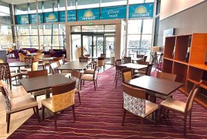 韦瑟比韦瑟比哈罗盖特戴斯酒店的用餐室设有桌椅和窗户。