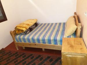 Aït TamellilGuest House Imdoukal的一张床上床,上面有一条毯子,放在一个房间里