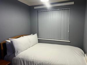 索利赫尔Becky's Lodge - Strictly Single Adult Room Stays - No Double Adult Stays Allowed的卧室配有白色的床和窗户