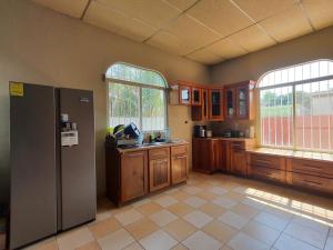 弗洛勒斯Habitacion cerca del lago的厨房配有不锈钢冰箱和2扇窗户
