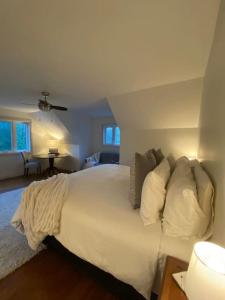 woodviewKerryAnne - North Kawartha Lakehouse with Hot Tub的一间卧室配有带白色床单和枕头的床。