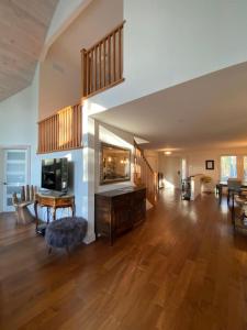 woodviewKerryAnne - North Kawartha Lakehouse with Hot Tub的一间铺有木地板并设有一个楼梯的大客厅