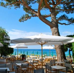 CavoliHotel Lorenza B&B e Mini Suite的海滩上设有桌椅和白色遮阳伞