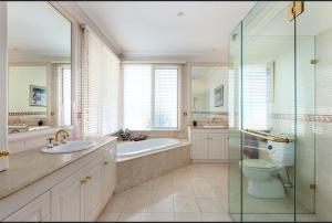 墨尔本Luxurious Townhouse Retreat in Prestigious Brighton的带浴缸、卫生间和盥洗盆的浴室