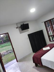 皮塔利托Hospedaje villa luz的卧室配有一张床,墙上配有电视。