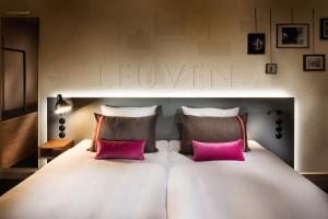 鲁汶pentahotel Leuven的一张带两个粉红色枕头的大型白色床