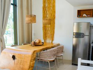圣米格尔-杜斯米拉格里斯Casa TUA的厨房配有桌椅和冰箱。