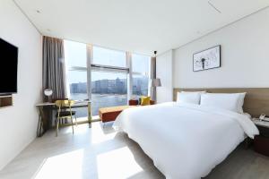 釜山Ocean 2 Heaven Hotel的一间酒店客房,设有一张大床和一个大窗户