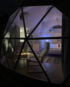 Rahwat al BarrAlbaha domes的客房享有带1张床和椅子的客房的景致。