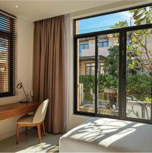 金兰Big Star Villas - Wyndham Garden的一间卧室配有一张床、一张书桌和一个大窗户